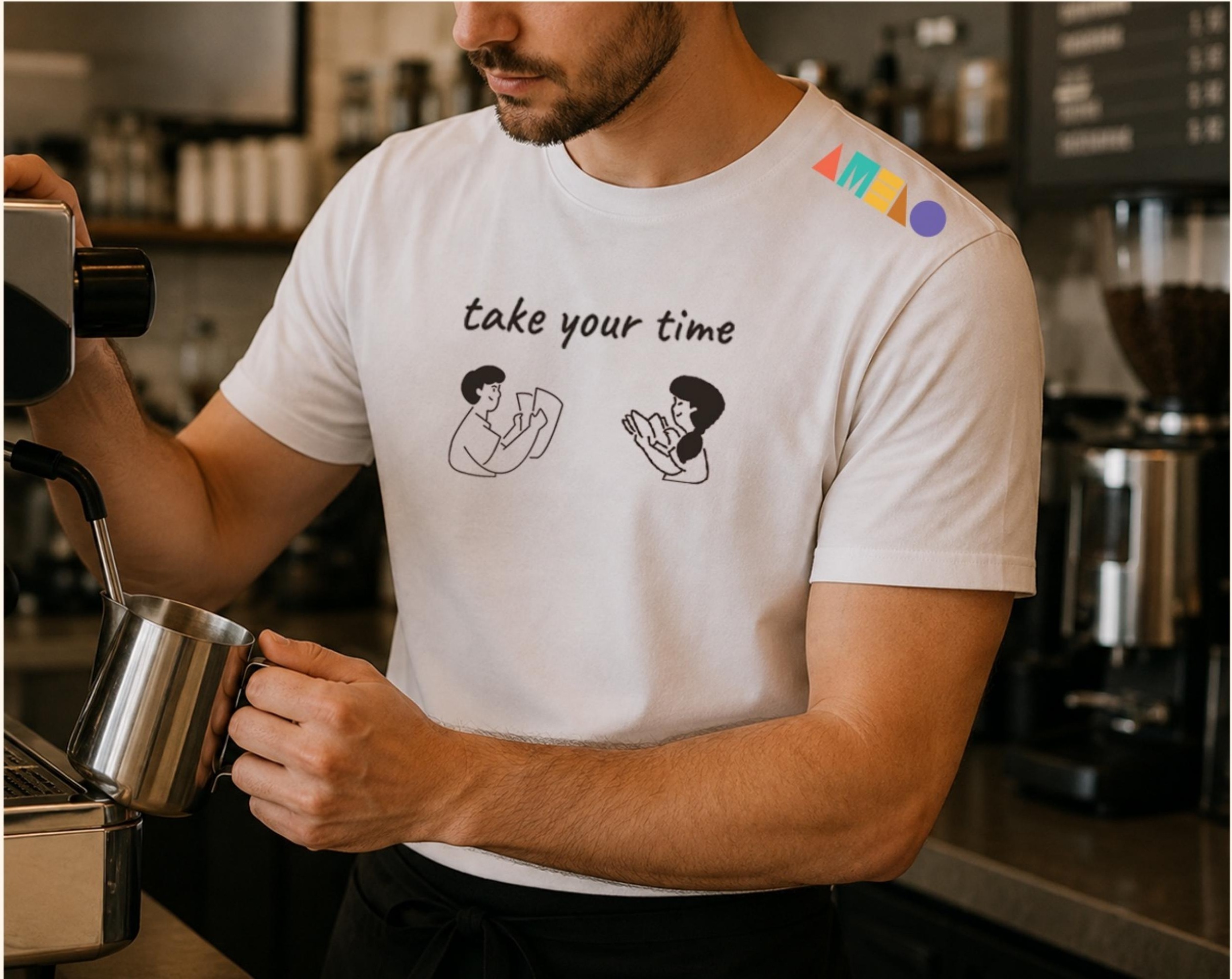 Barista wearing a white t-shirt with the take your time slogan, illustrated characters and a small logo on the shoulder